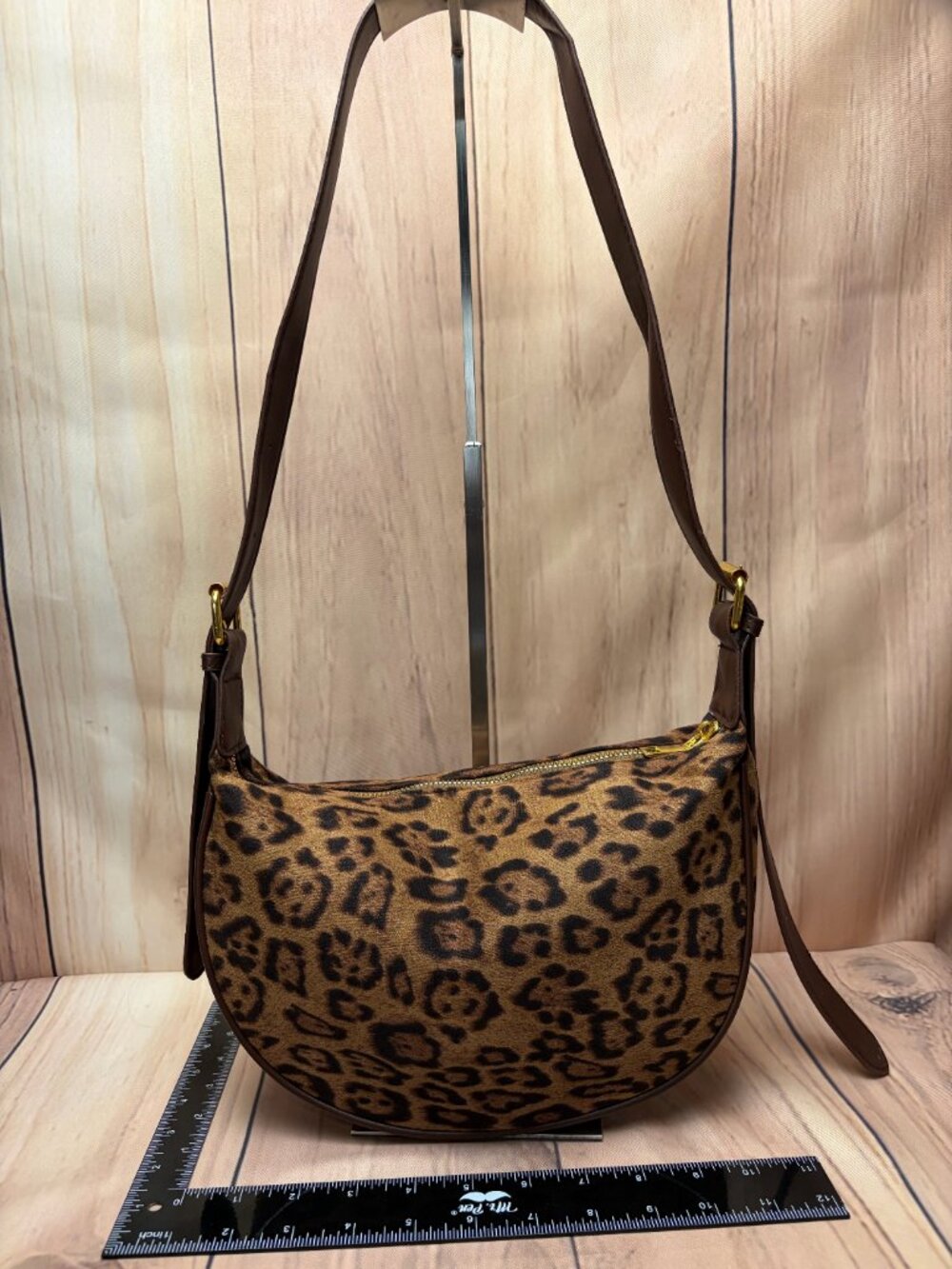 Leopard print crescent shoulder bag featuring a brown and black animal-print